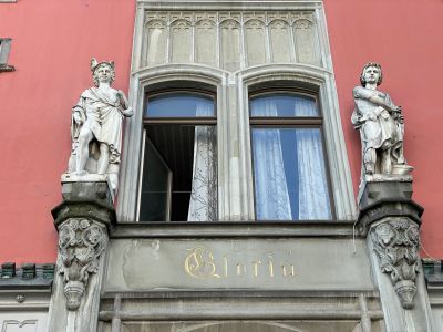 historicalFacade, statues, ornateArchitecture, stonework, archedWindow