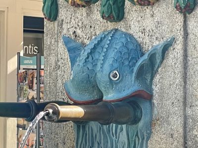 blue fish statue,  fountain outlet,  sculpture,  concrete wall,  water feature